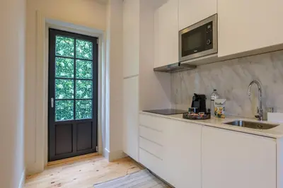 a kitchen with white cabinets and a black door at Art Deco 33 Luxury 2BR Apartment Downtown Metro AC in Porto