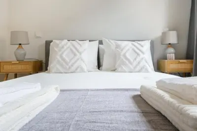 a bedroom with a large white bed with two night stands at Art Deco 12 Luxury 2BR Apartment Downtown Metro AC in Porto