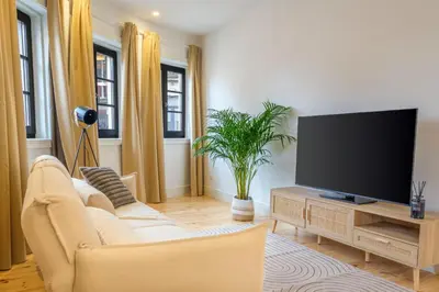 a living room with a television and a couch at Art Deco 22 Luxury 2BR Apartment Downtown Metro AC in Porto