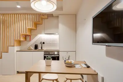 a kitchen with a wooden table and two chairs at Figueirôa Four Houses by DA'Home in Porto