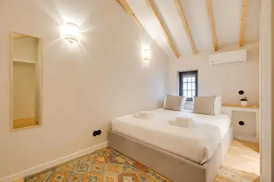 a white bedroom with a large bed in a room at Figueirôa Four Houses by DA'Home in Porto