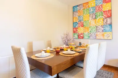a dining room with a wooden table with chairs at Bright & Spacious Flat by Host Wise in Porto