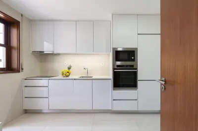 a white kitchen with a sink and a refrigerator at Bright & Spacious Flat by Host Wise in Porto