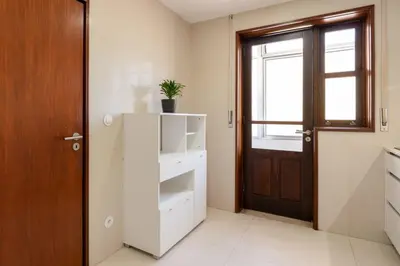 a white kitchen with a door and a plant at Bright & Spacious Flat by Host Wise in Porto