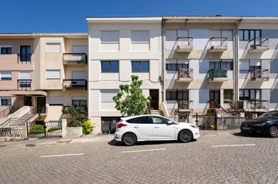 a white car parked in a parking lot in front of a building at Bright & Spacious Flat by Host Wise in Porto