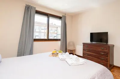 a bedroom with a bed with a tv and a dresser at Bright & Spacious Flat by Host Wise in Porto