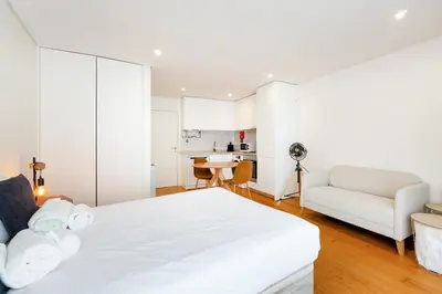 a white bedroom with a bed and a couch at GuestReady - Homely escape near Bolhão in Porto