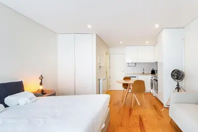 a white bedroom with a bed and a couch at GuestReady - Homely escape near Bolhão in Porto
