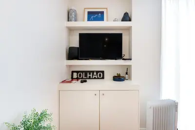 a living room with a tv and a white cabinet at GuestReady - Homely escape near Bolhão in Porto