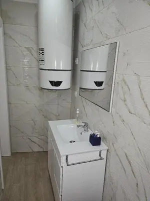 a white bathroom with a sink and a mirror at Apartamento Camões in Porto