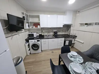 a small kitchen with a table and a microwave at Apartamento Camões in Porto