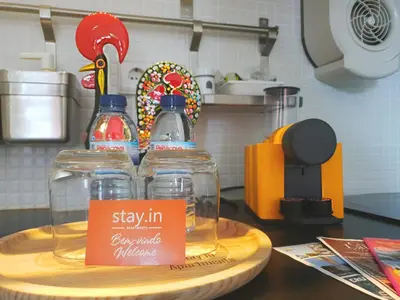 two glass bottles on a wooden tray on a kitchen counter at Stay in Apartments Ribeira 24 in Porto