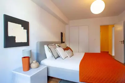 a bedroom with a bed with an orange blanket at Porto Downtown Flats in Porto
