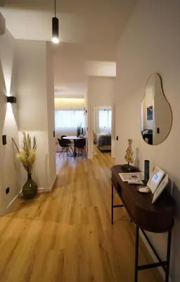 a living room with a wooden floor and a table at Crystal Palace Oporto Flat - With Two Bedrooms in Porto