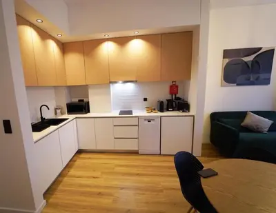 a kitchen with white cabinets and a table and a couch at Crystal Palace Oporto Flat - With Two Bedrooms in Porto