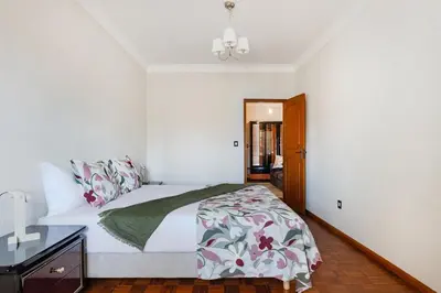 a white bedroom with a bed and a night stand at Ildefonso Oporto Stay in Porto