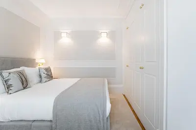 a white bedroom with a bed and lights on the wall at GuestReady - Elisium Star in Porto