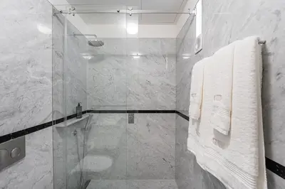 a bathroom with a glass shower with white towels at GuestReady - Elisium Star in Porto