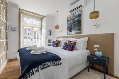 a bedroom with a large white bed and a window at OPO Ribeira I in Porto