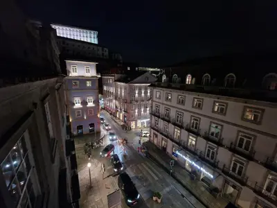a city street at night with cars and buildings at OPO Ribeira I in Porto