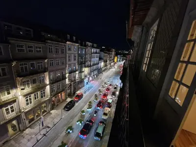 a city street with cars parked on the street at night at OPO Ribeira I in Porto