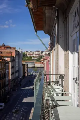 a balcony with white chairs and a view of a street at OPO Ribeira I in Porto