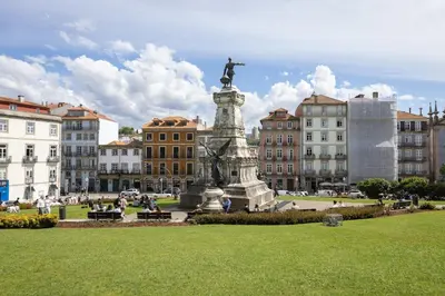 a statue in the middle of a city with buildings at OPO Ribeira II in Porto