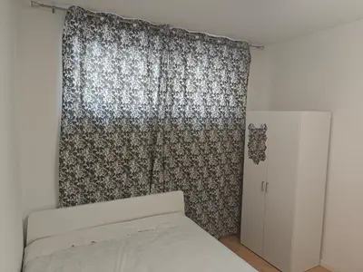 a bedroom with a bed and a curtain at Ap Recanto do Pilar 5 min Ponte Luis in Vila Nova de Gaia