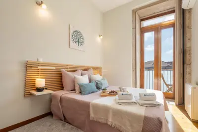 a bedroom with a large bed with a window at HostWise - Stylish Flat with Balcony in Porto