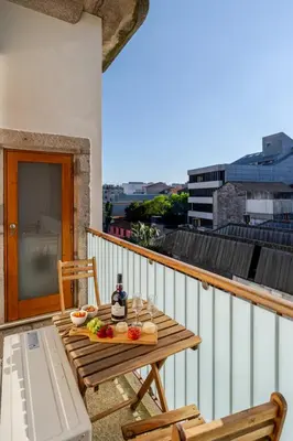 a wooden table on a balcony with food on it at HostWise - Stylish Flat with Balcony in Porto