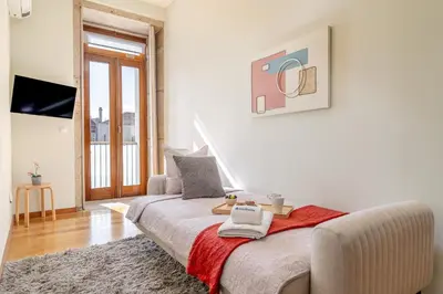 a white room with a bed and a television at HostWise - Stylish Flat with Balcony in Porto