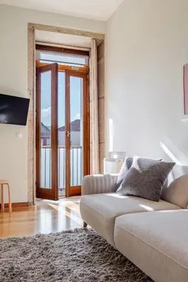 a living room with a couch and a large window at HostWise - Stylish Flat with Balcony in Porto
