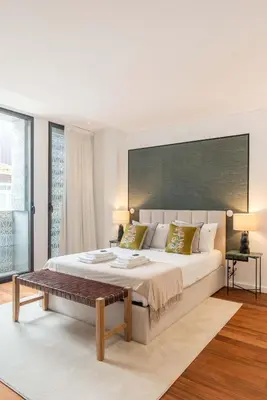 a white bedroom with a large bed and a table at Liiiving in Porto - The Prestige Apartment A in Porto