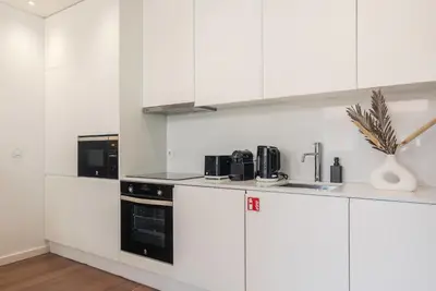 a kitchen counter with a sink and a vase with a plant at Liiiving in Porto - The Prestige Apartment A in Porto