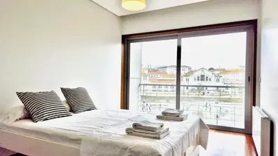 a bedroom with a bed with a large window at VER Torrinha -Porto in Porto