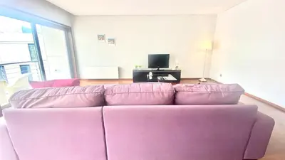 a purple couch in a living room with a tv at VER Torrinha -Porto in Porto