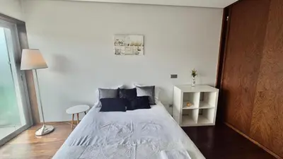 a bedroom with a large white bed with blue pillows at VER Torrinha -Porto in Porto