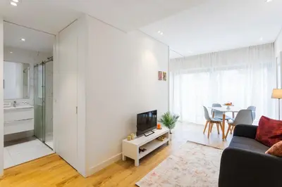 a living room with a couch and a tv and a table at Studio w/ Terrace, Pool & Gym | Antas by Host Wise in Porto