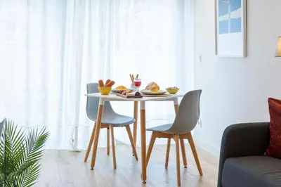 a table and chairs in a living room at Studio w/ Terrace, Pool & Gym | Antas by Host Wise in Porto
