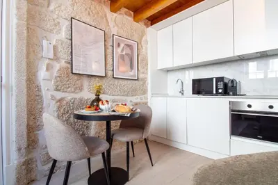 a small kitchen with a table and two chairs at Cozy Mezzanine Hideaway w AC by LovelyStay in Porto