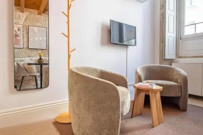 a living room with two chairs and a table at Cozy Mezzanine Hideaway w AC by LovelyStay in Porto