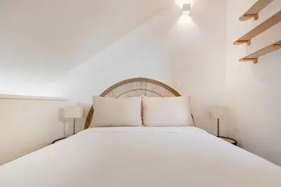 a bedroom with a large white bed in a attic at Saldanha Boho Duplex in Porto