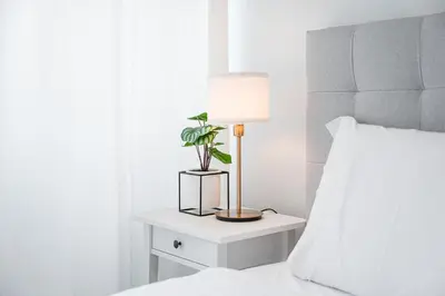 a bedside table with a lamp and a plant on it at GuestReady - Homely retreat in the city centre in Porto