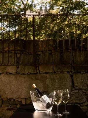 a bottle of wine and two glasses on a table at Malmerendas Boutique Lodging in Porto