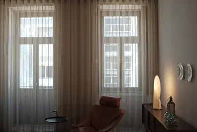 a living room with a chair and two windows at Malmerendas Boutique Lodging in Porto