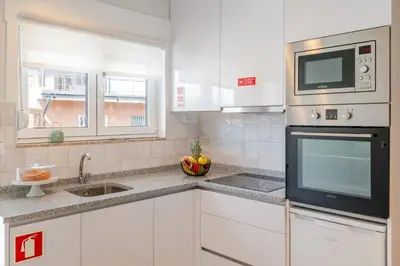 a white kitchen with a microwave and a sink at HostWise - Quinta do Vintém w/ Terrace near WOW in Vila Nova de Gaia