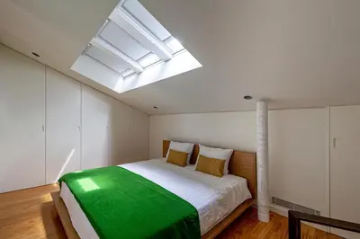 a bedroom with a large bed with a skylight at 5daMaria - Porto Center in Porto
