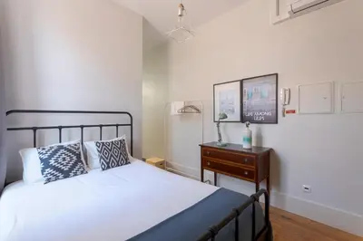 a bedroom with a bed and a dresser with a lamp at Viela Chic by Cozy Stay in Porto