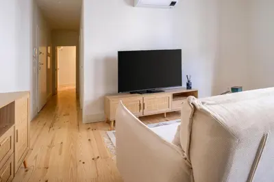 a living room with a television and a couch at Art Deco 21 Luxury 2BR Apartment Downtown Metro AC in Porto