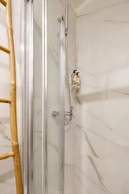 a shower with a glass door in a bathroom at Art Deco 21 Luxury 2BR Apartment Downtown Metro AC in Porto